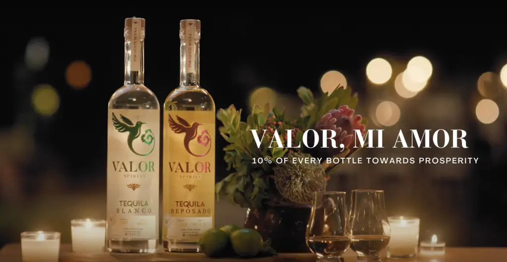Blanco + Reposado Bottle sit in candlelight, with text that reads "Valor, Mi Amor" and a subline that says "10% for prosperity.